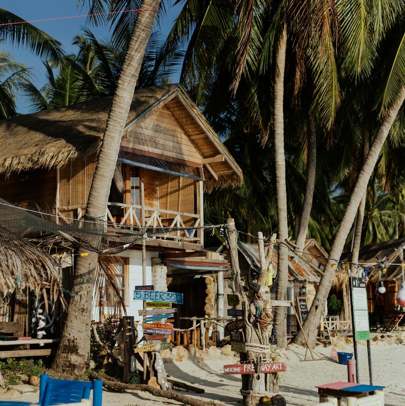 Brown Wooden Houses On Beachside Under Coconut Trees